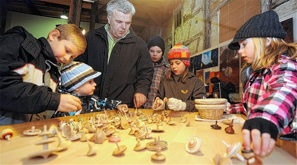 Auf dem Kunsthandwerkermarkt in der Kelter bietet ein Drechsler seine Kreisel an. Die Kinder dürfen die kleinen Wunderwerke gleich ausprobieren. Fotos: Fotomoment (2)/Filitz