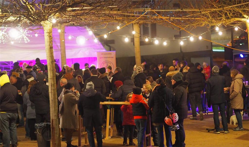 Auf dem festlich beleuchteten Maulbeerbaumplatz in den Mühlacker Enzgärten genießen beim Glühweinfest des Musikvereins zahlreiche Besucherinnen und Besucher die winterliche Atmosphäre und das gesellige Beisammensein. Foto: Müller