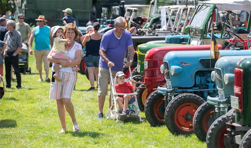Auf den Armen von Angela Grosch zeigt schon die kleine Enkelin Nora großes Interesse an den Landmaschinen. Foto: Fotomoment