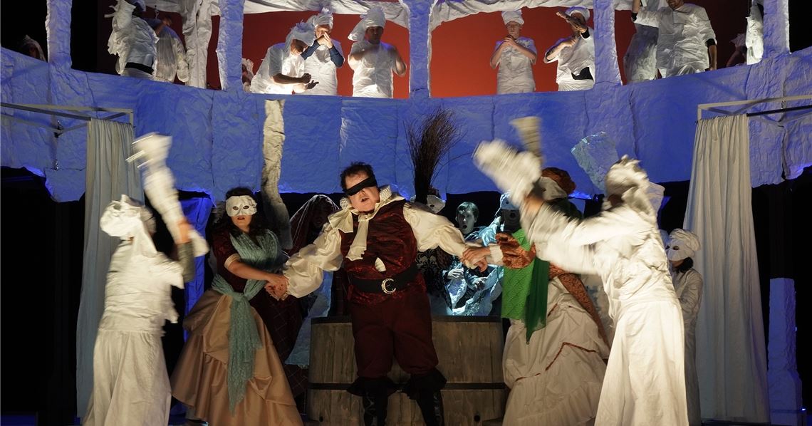 Auf der Bühne geht es beim Pforzheimer „Falstaff“ von Thomas Münstermann hoch her. Hier wird Bariton Rhys Jenkins als Sir John Falstaff umzingelt.Foto: Theater Pforzheim/Sebastian Seibel