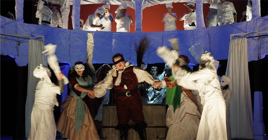 Auf der Bühne geht es beim Pforzheimer „Falstaff“ von Thomas Münstermann hoch her. Hier wird Bariton Rhys Jenkins als Sir John Falstaff umzingelt.Foto: Theater Pforzheim/Sebastian Seibel