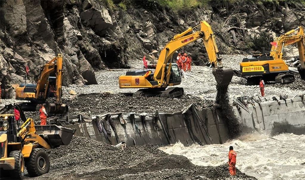 Auf diesem von der Nachrichtenagentur Xinhua veröffentlichten Foto sind Rettungskräfte zu sehen, die mit schwerem Gerät eine Straße freiräumen, die zu den von Schlammlawinen betroffenen Gebieten in Xigaze in der Autonomen Region Tibet im Südwesten Chinas führt.