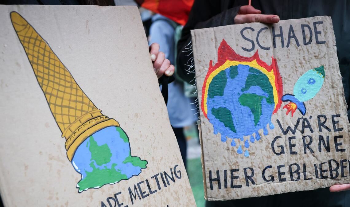 Auf einem Klimaprotest machen Plakate auf die eskalierende Krise aufmerksam. (Symbolbild)