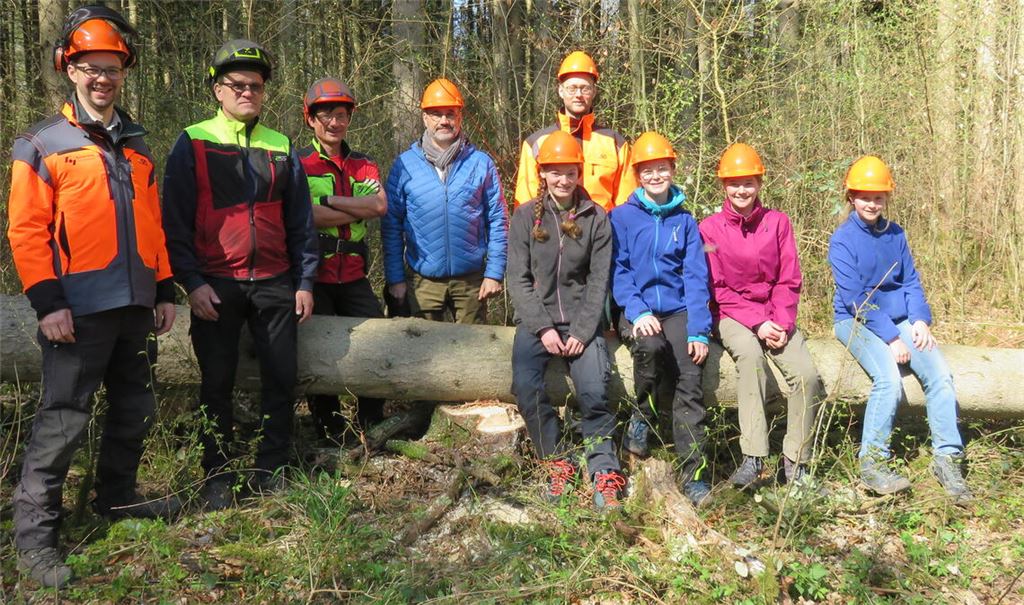 Auf einer frisch von Jonathan Bube (3.v.li.) gefällten Fichte nehmen Teilnehmerinnen des Girls‘ Day Platz. Weitere Schülerinnen befinden sich zu diesem Zeitpunkt an anderen Mitmachstationen im Mühlacker Stadtwald. Unter anderen machen sich Bürgermeister Armin Dauner (blaue Jacke) und neben ihm Dezernent Holger Nickel ein Bild. Fotos: Becker