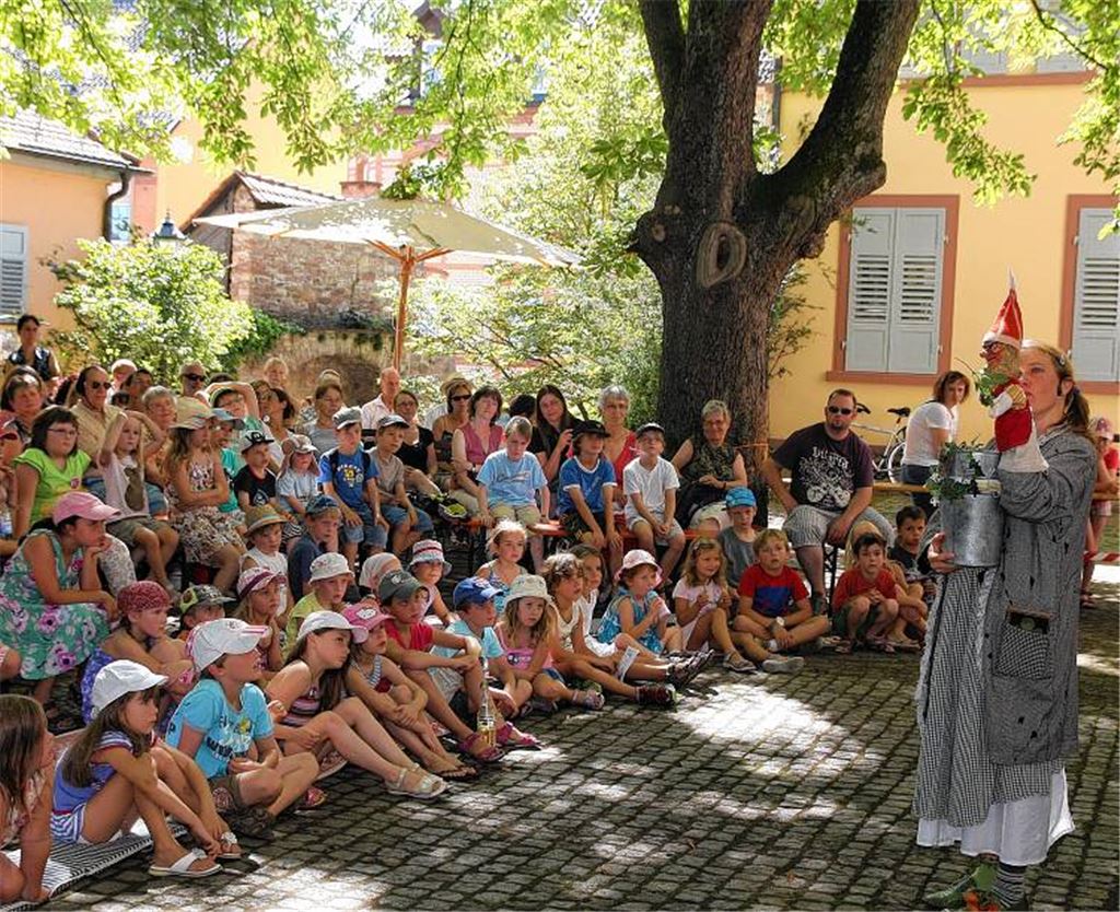 Aufmerksam lauschen Kinder der Geschichte von Flora Primelwurz. 