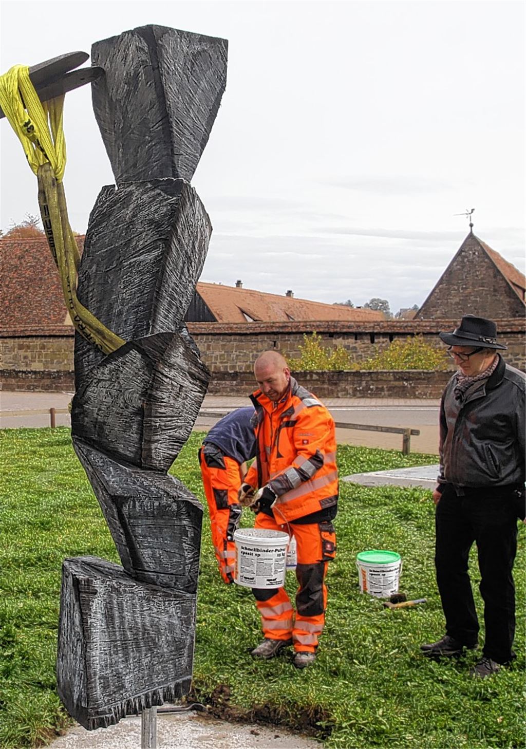 Aufmerksam verfolgt Bildhauer Karl Manfred Rennertz, wie seine Holzskulptur beim Skulpturenweg aufgestellt wird. 