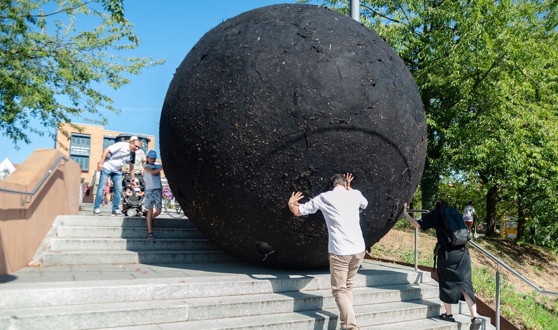 Macher glauben an die „Ornamenta“-Idee Aufsehenerregendes „Ornamenta“-Projekt: Der riesige „Black Ball“ wird durch Mühlacker gerollt. Fotos: Fotomoment, Friedrich
