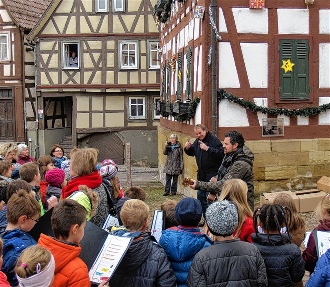 Auftakt am 2. Dezember: Knittlinger Schulkinder singen zu Füßen des Adventshauses – und der Bürgermeister dirigiert.