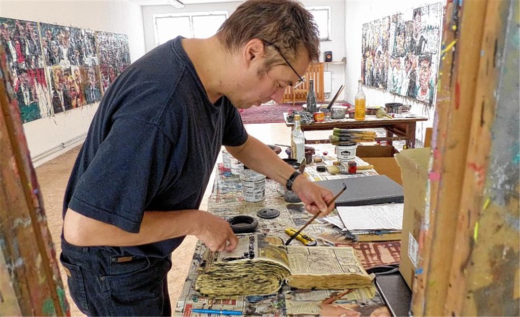 Außer der Serie „Europa hat gewählt und ist erstaunt über das Ergebnis“ (im Hintergrund) entsteht am Tisch auch eine Art Collagenbuch.