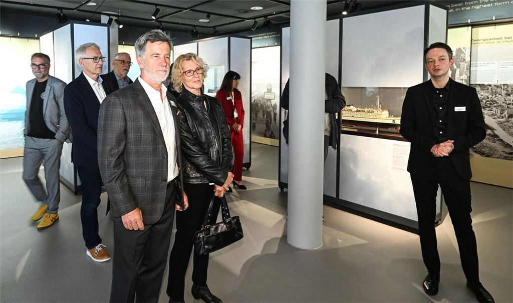 Ausstellungsmacher David Pfeffer (re.) erläutert Ulrich und Kathrin Schmid-Maybach (Mitte) die Ausstellung im Maybach Schaudepot in Friedrichshafen.