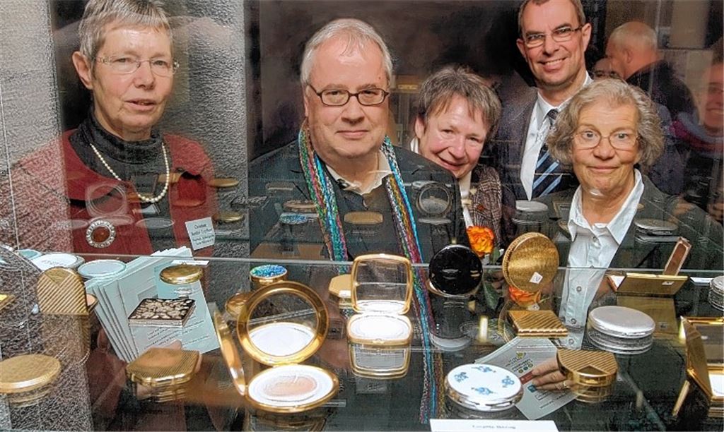 Ausstellungsorganisatorin Christiane Bastian-Engelbert, Redakteur Steffen Pross (v.li.), Marianne Knappe und deren Schulfreundin Ursel Ahner (vorne v.re.) sowie Mühlackers Oberbürgermeister Frank Schneider betrachten Produkte, die in der Bijouterie-und Kettenfabrik Emrich hergestellt wurden. Foto: Fotomoment