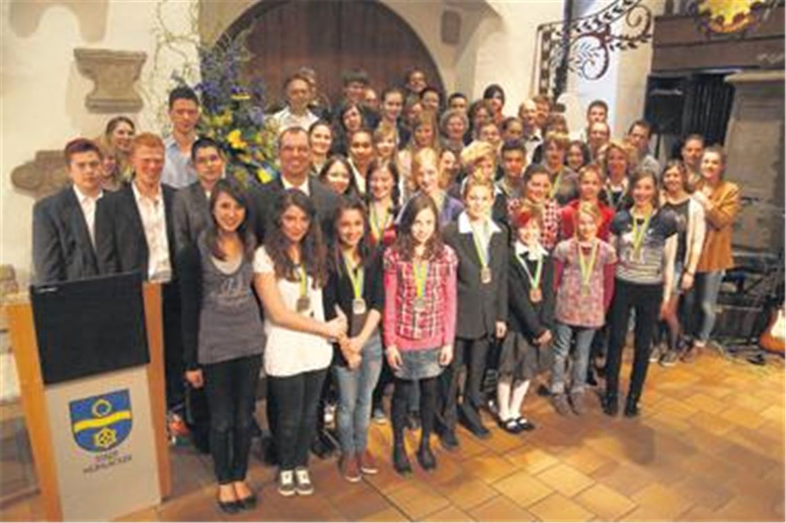 Auszeichnung als Ansporn für weitere Leistungen: Fast fünf Dutzend Athleten erhalten in der historischen Kelter funkelnde Medaillen umgehängt. 
Foto: Eigner