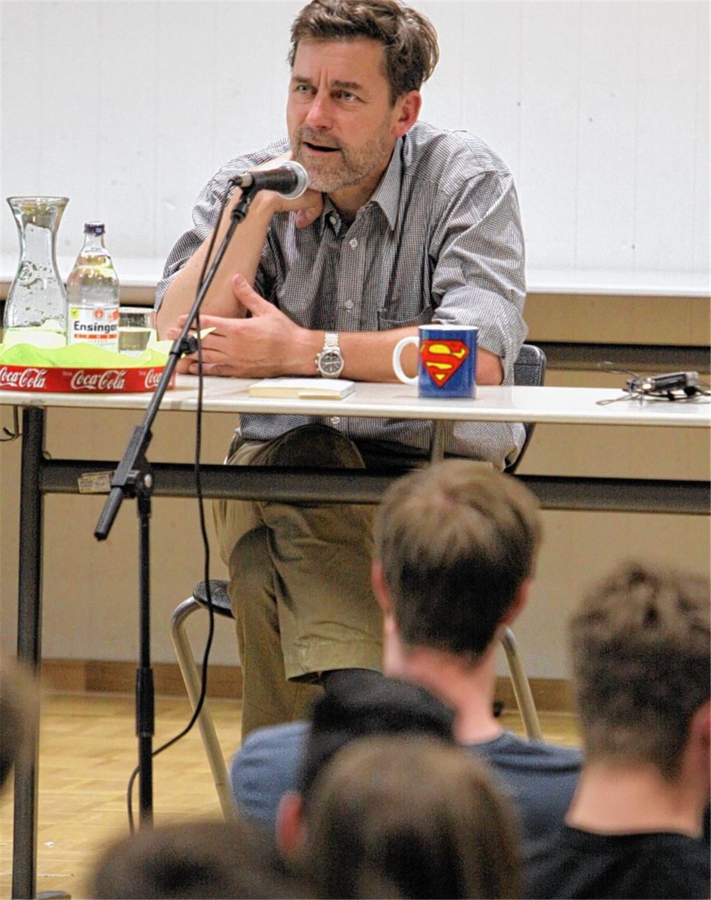 Autor Peter Stamm steht Schülern des THG Rede und Antwort. Dabei liegt ihm die Rolle des Superhelden fern, auch wenn die auffällige Tasse einen anderen Eindruck vermitteln könnte.