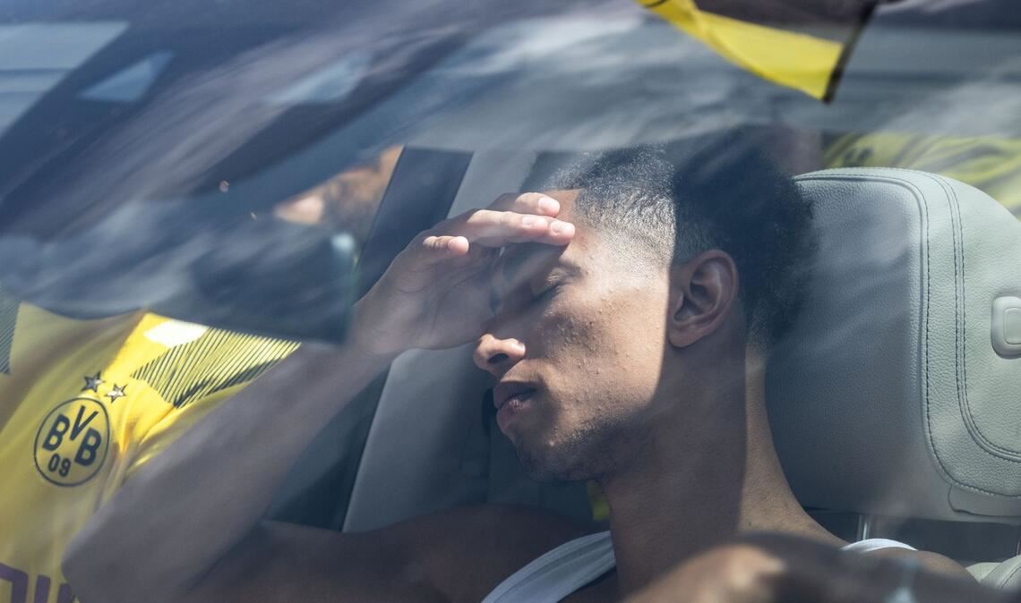 BVB-Spieler Jude Bellingham sitzt nach einer Mannschaftssitzung am Rande des Trainingsgeländes im Auto.