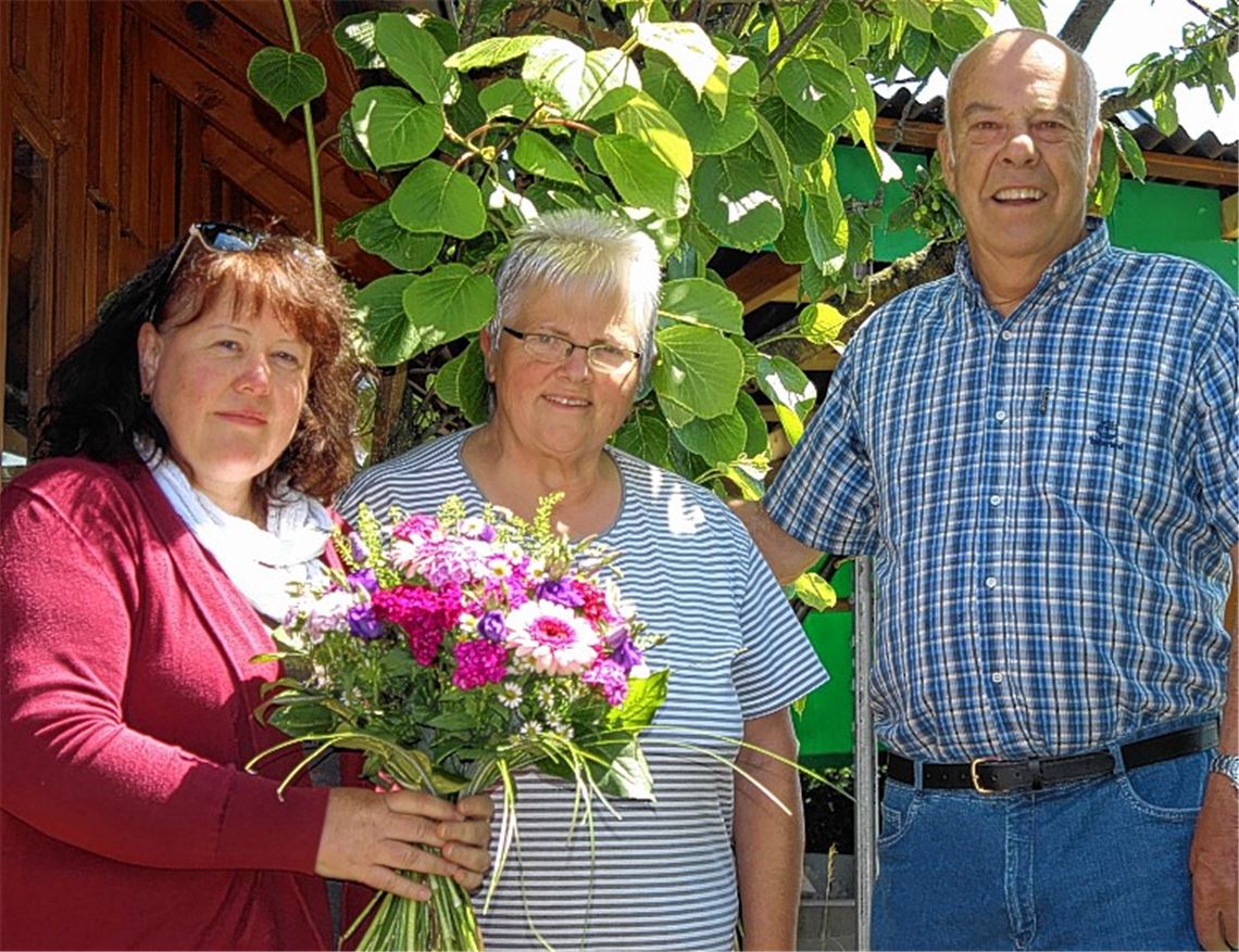 Barbara Odenwälder vom MT (li.) übergibt den Blumenstrauß an Herbert und Magdalene Steimle aus Wiernsheim.