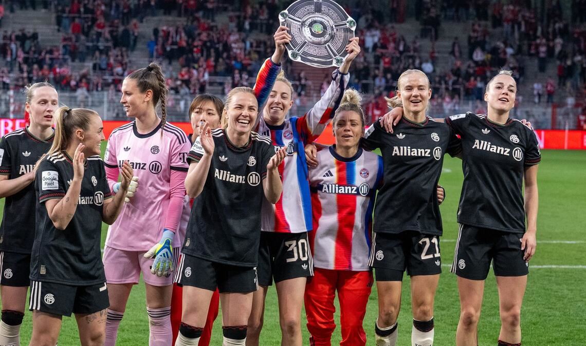 Bayern Münchens Spielerinnen jubeln nach dem Spiel gegen den 1. FC Union Berlin mit der Nachbildung einer Meisterschale über den Sieg.