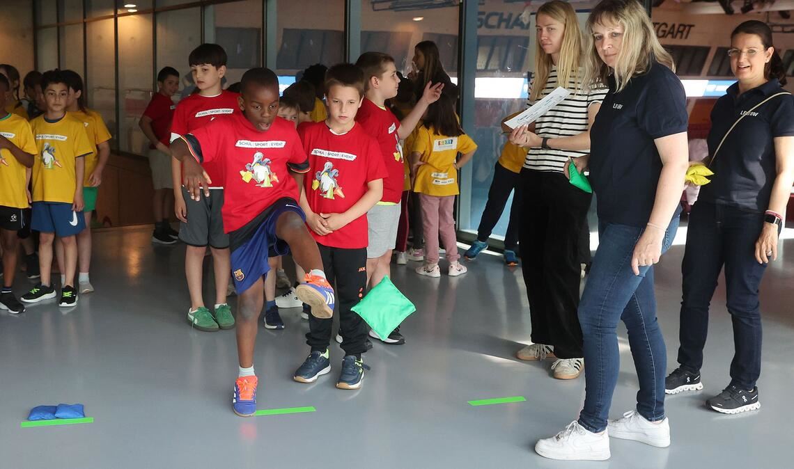 Bei der Affen-Station beweisen die Schüler ihre Geschicklichkeit. Mit dem Fuß soll das Sandsäckchen in den Reifen gekickt werden.