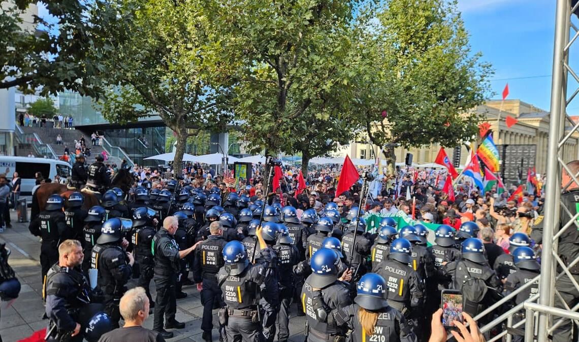 Bei der Rede von Sevim Dağdelen bewegen sich plötzlich Vermummte in Richtung der Bühne. Die Polizei muss eingreifen.