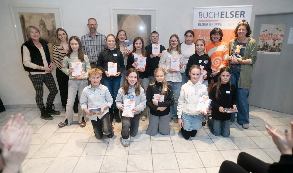 Beifall für alle Vorleserinnen und Vorleser. Mit den Sechstklässlerinnen und Sechstklässlern freuen sich (hinten von li.) die Jurymitglieder Claudia Heiler, Adriana Leitao und Steffen Roller sowie (hinten v.re.) Carolin Britsch und Angelika Wetzel von Buch-Elser. Vorne kniend zu sehen sind (v.li.) Theo Wallinger, Lilli Deckenbach, Ava Schäfer, Clara Weiß und Ida Albrecht. Stehend (v.li.) Gewinnerin Mia Drollinger, Johanna Mayer, Sofia Merkt, Leni Keck, Davide Paterno, Emma Reiling, Iva Korov und Finja Freitag. Fotos: Fotomoment