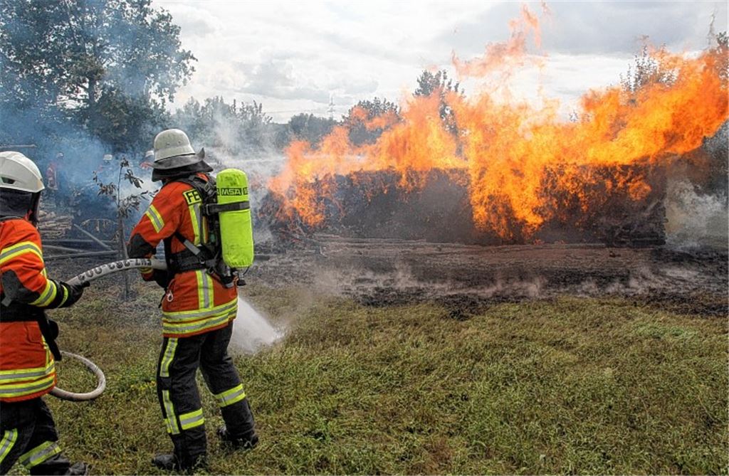 Beim Eintreffen der Feuerwehr steht der Holzstapel bereits in Flammen.