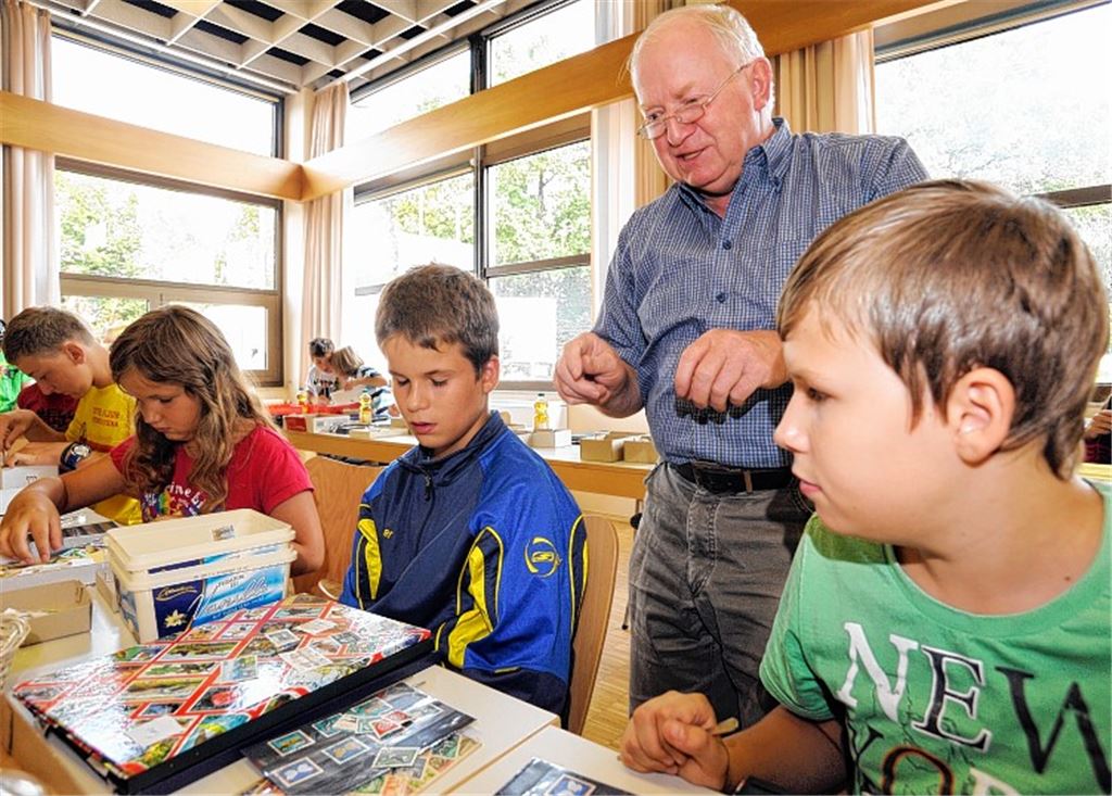 Beim Kinderferienprogramm „Rund um die Briefmarke“ in Ötisheim macht Wolfgang Lichtner Vorschläge für Sammelthemen. Foto: Fotomoment