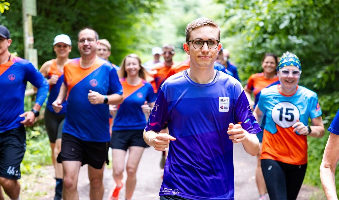 Beim gemeinsamen Training im Wald bereitet sich Fynn (M.) mit anderen Läuferinnen und Läufern auf die nationalen Spiele der Special Olympics vor.