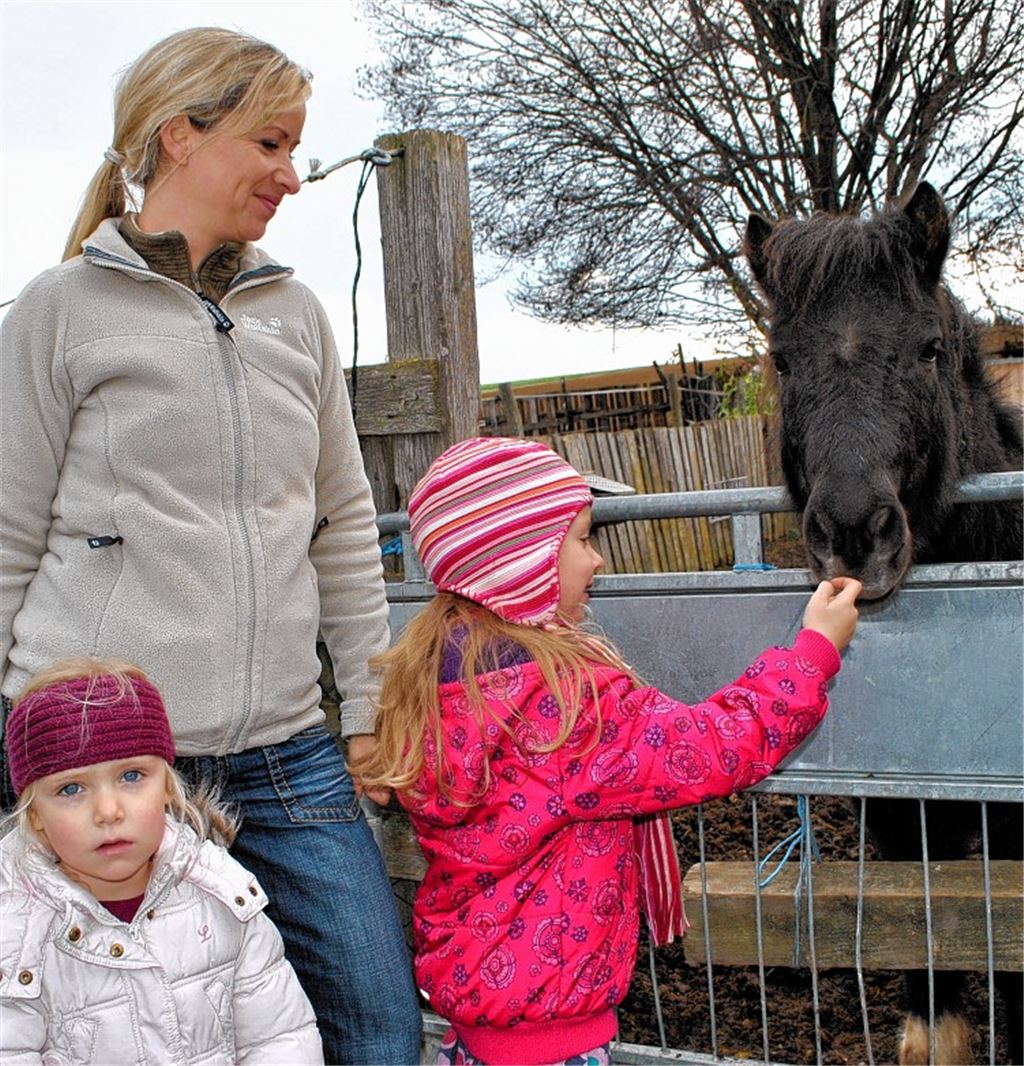 Besuch auf dem Gnadenhof: Beim Adventsbasar präsentiert die Leiterin des Tierasyls, Felicia Ruhland (2.v.re.), den neuen Wandkalender.