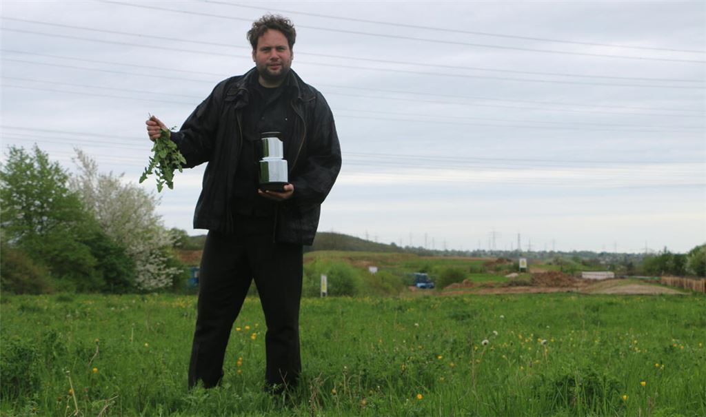 Besuch mit kurzem Kaffeekränzchen auf der Wiese, auf der der Ziegelgarten für die Ornamenta entstehen wird: Jules van den Langenberg betont, dass dort nur die Pflanzen wachsen sollen, die ohnehin dort blühen, und freut sich über den Ausblick auf die Ziegelhöhe-Baustelle im Hintergrund. Foto: Deeg