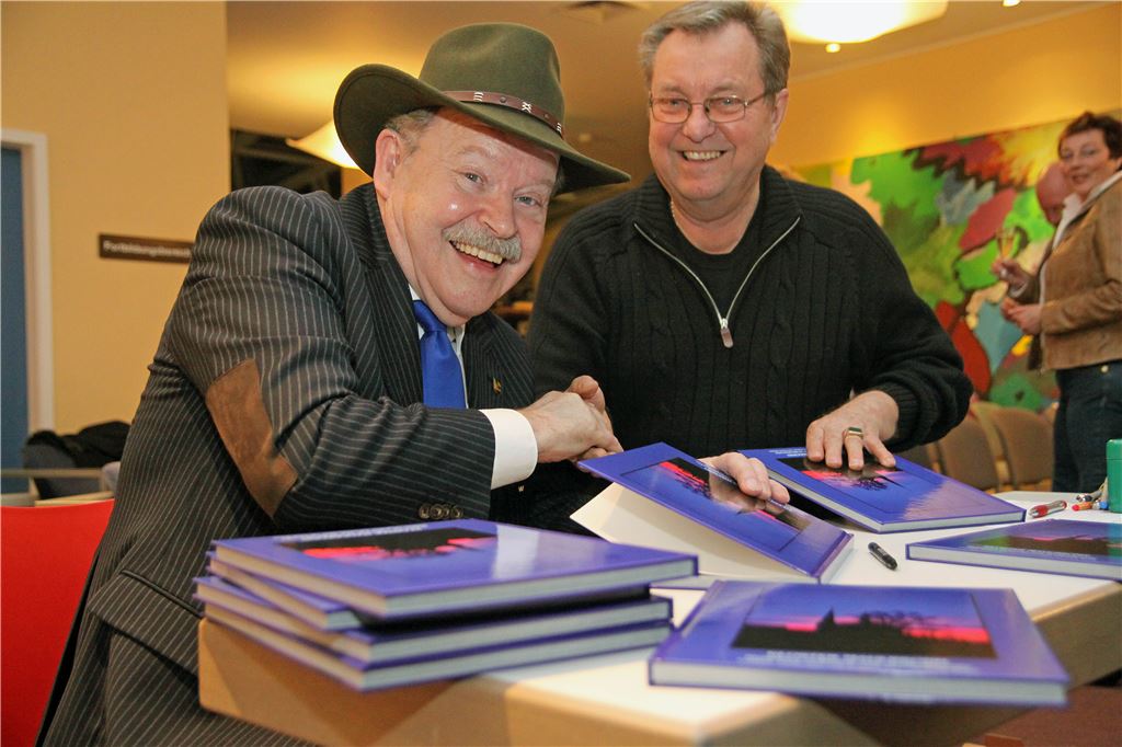 Besucher Werner Hanke (rechts) gratuliert Fotograf Erich Blaich zur gelungenen Diashow und kauft auch gleich einen Bildband zum Kloster Maulbronn.  Foto: Hansen