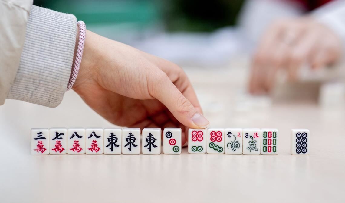 Besucher spielen bei dem chinesisches Neujahrsfest in den Gewächshäusern der Botanika in Bremen das chinesische Gesellschaftsspiel Mah-Jongg.