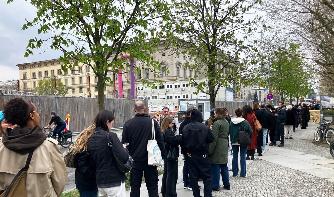 Besucher stehen Schlange vor der Ausstellung.