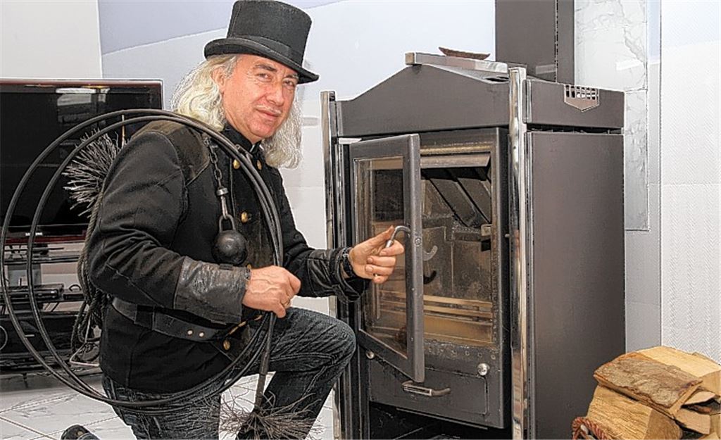 Bezirksschornsteinfeger Fredy Geist mit Kehrgeschirr und traditionellem Zylinder. 