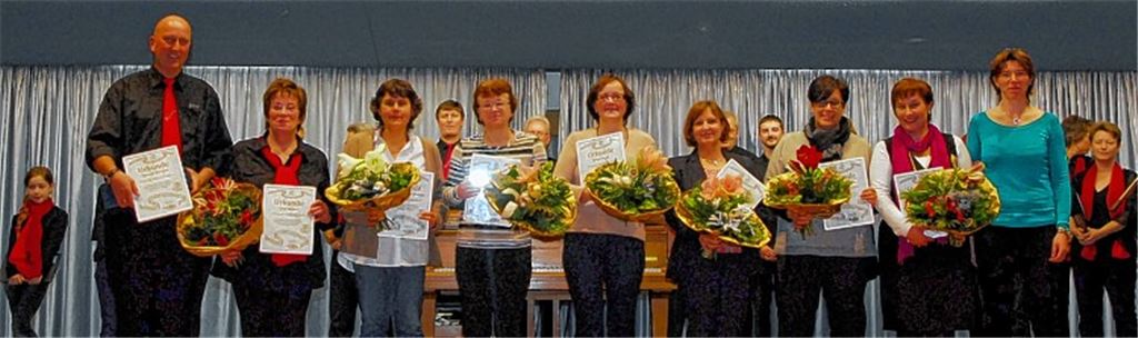 Bianca Iluan (re.) ehrt aktive Mitglieder des „Liederkranzes“. Fast alle haben als Gründungsmitglieder im neuen Kinderchor angefangen (v. li.): Thomas Schrenk, Lore Geiger, Sabine Wilhelm-Maaßen, Annette Bühler, Birgit Frank, Gabriele Riede, Sabine Arnold und Christine Schrenk.