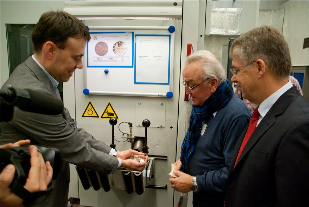 Künstler Eugen Ruhl (M.), Münzleiter Dr. Peter Huber (re.) und der baden-württembergische Finanzminister Dr. Nils Schmid bei der Anprägung der Maulbronner Sondermünze in Stuttgart.  