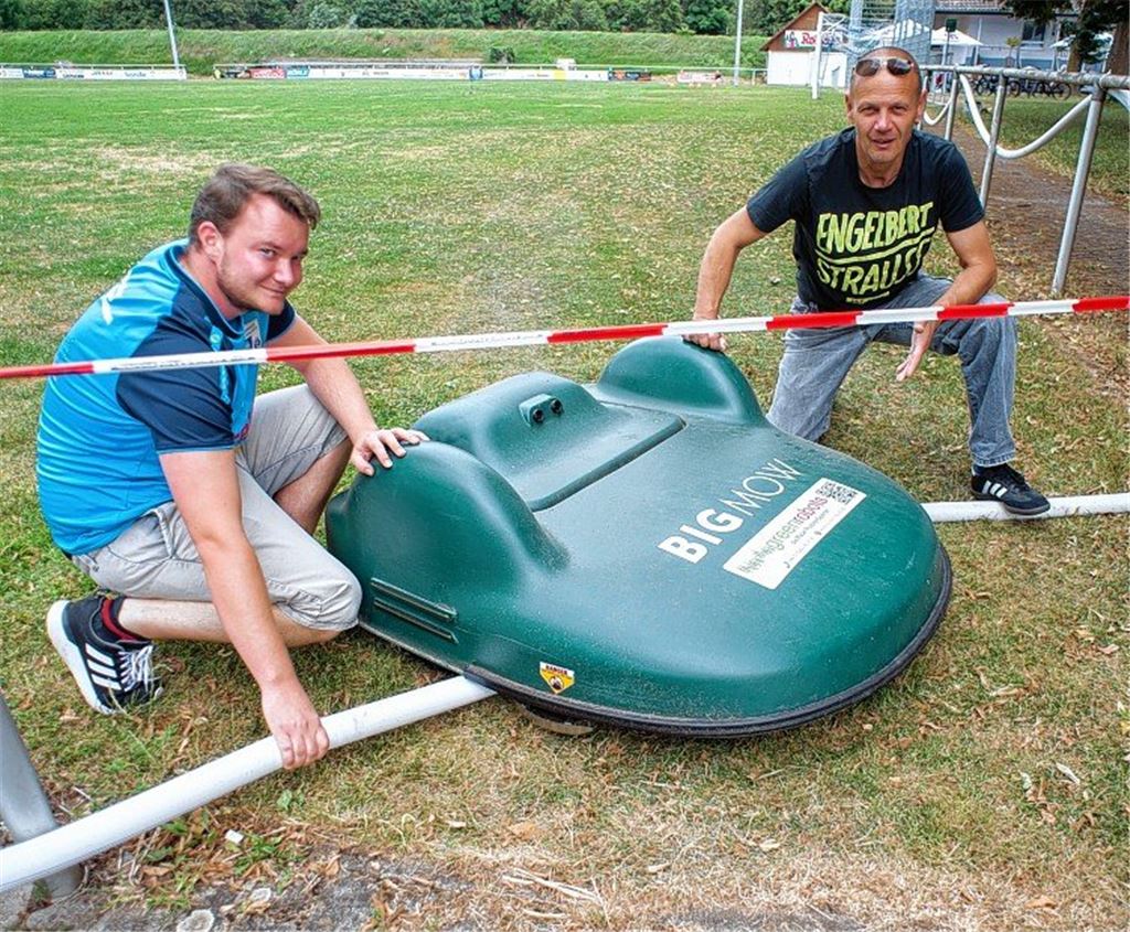 Vater lässt Kind auf Mähroboter reiten