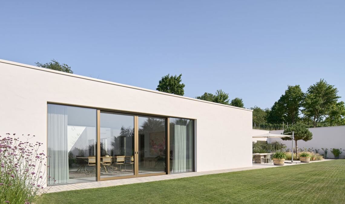 Blick auf die Westfassade und seitlichen Garten: Daniel Henecka baute das Haus für die Familie Klumpp in den Weinberg hinein.
