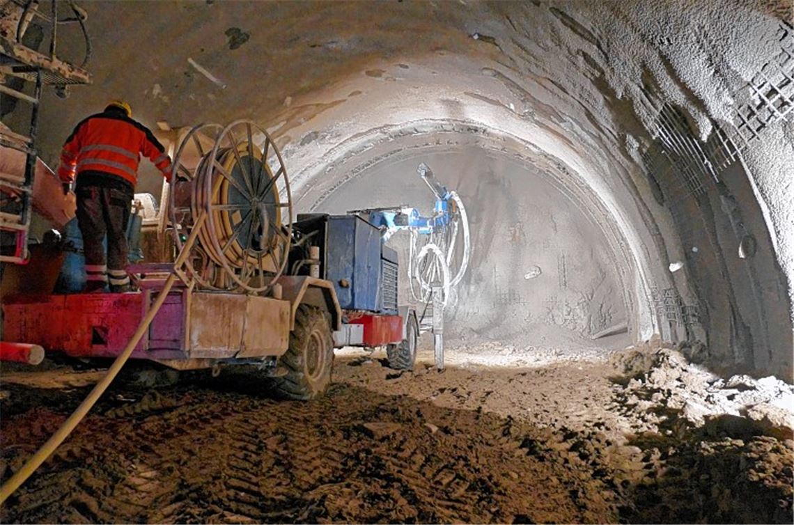 Blick in den Tunnel: Eine Betonmischmaschine bringt den Spritzbeton auf, der als Sicherung dienen soll. Der Lkw steht auf einer Art Podest.Roth