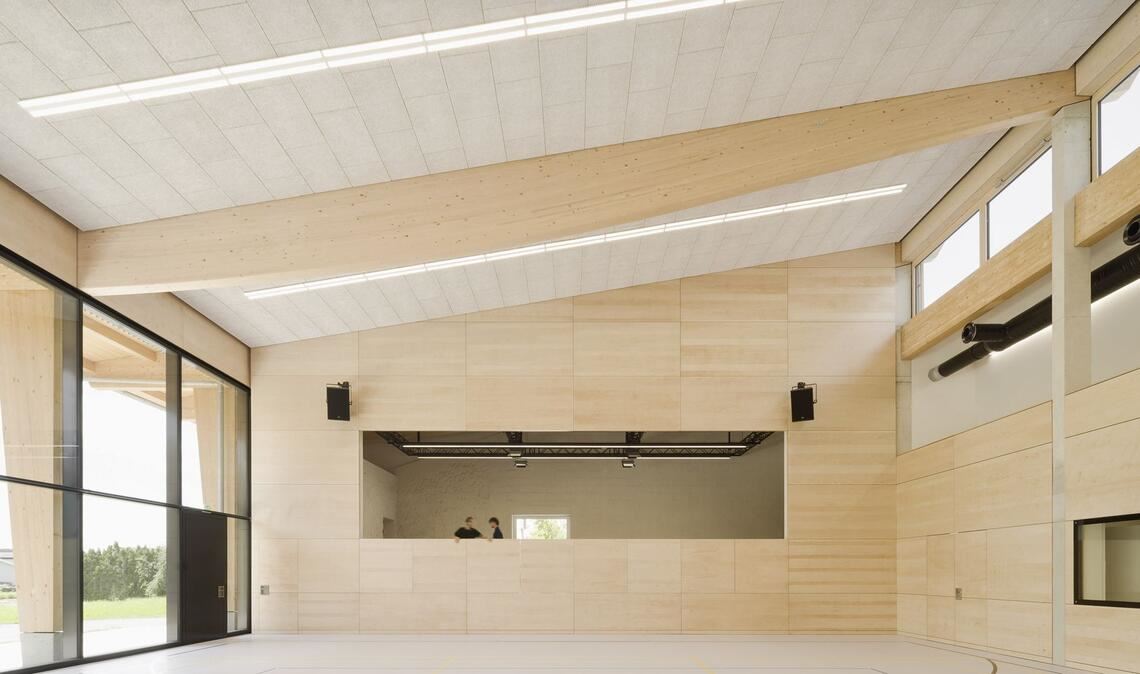 Blick in die Halle mit Holztragwerksbalken. Der hintere Teil der Halle kann auch  zum Theater spielen genutzt werden.