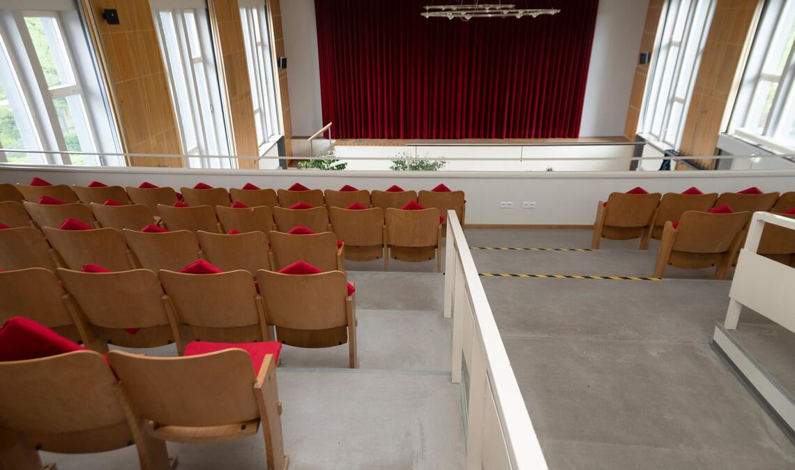 Blick über Stuhlreihen der Empore im Mühlacker Uhlandbau zur Bühne. Foto: Fotomoment