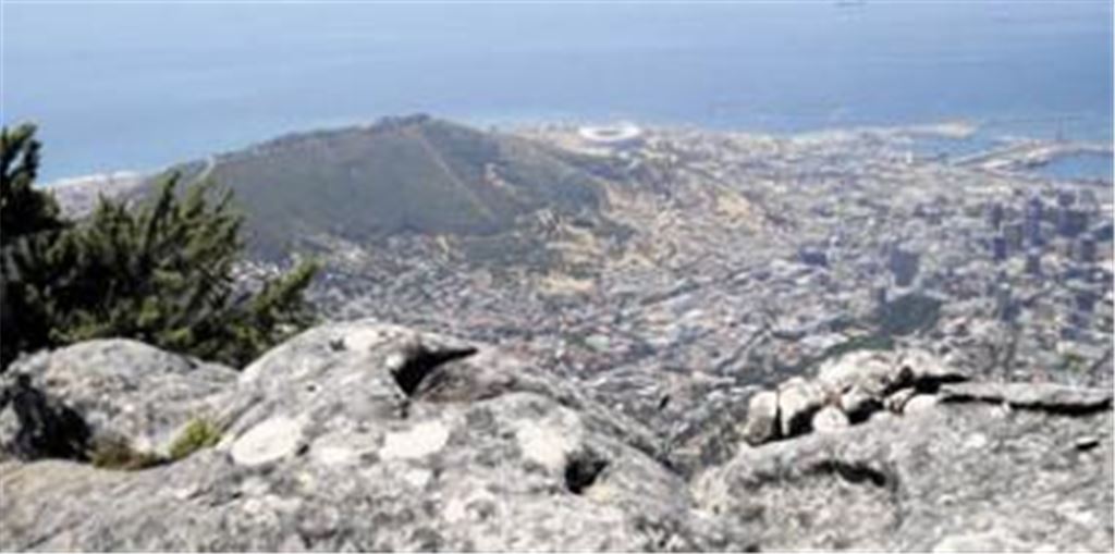 Blick vom Tafelberg auf Kapstadt mit seinem WM-Stadion (Bildmitte, direkt an der Küste). Die beeindruckenden Ansichten in Südafrika passen nicht immer zu den inneren Problemen des Landes. Foto: p