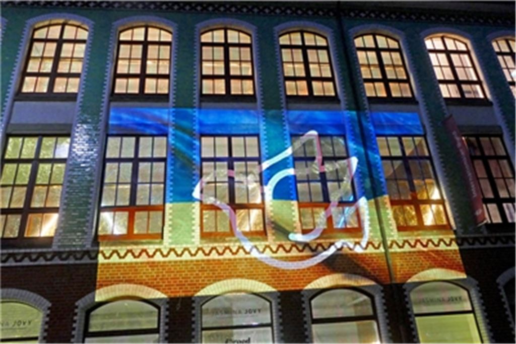 Blickfang und wichtiges Signal: Die Fassade des Kollmar&Jourdan-Gebäudes, dessen Fenster mit Rettungsdecken verkleidet sind, wird mit Friedenssymbolen beleuchtet. Fotos: Roth