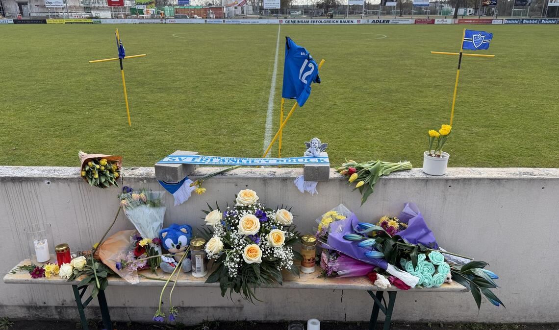 Blumen und Kerzen sind an einem Fußballplatz im Ortsteil Bruck aufgestellt.
