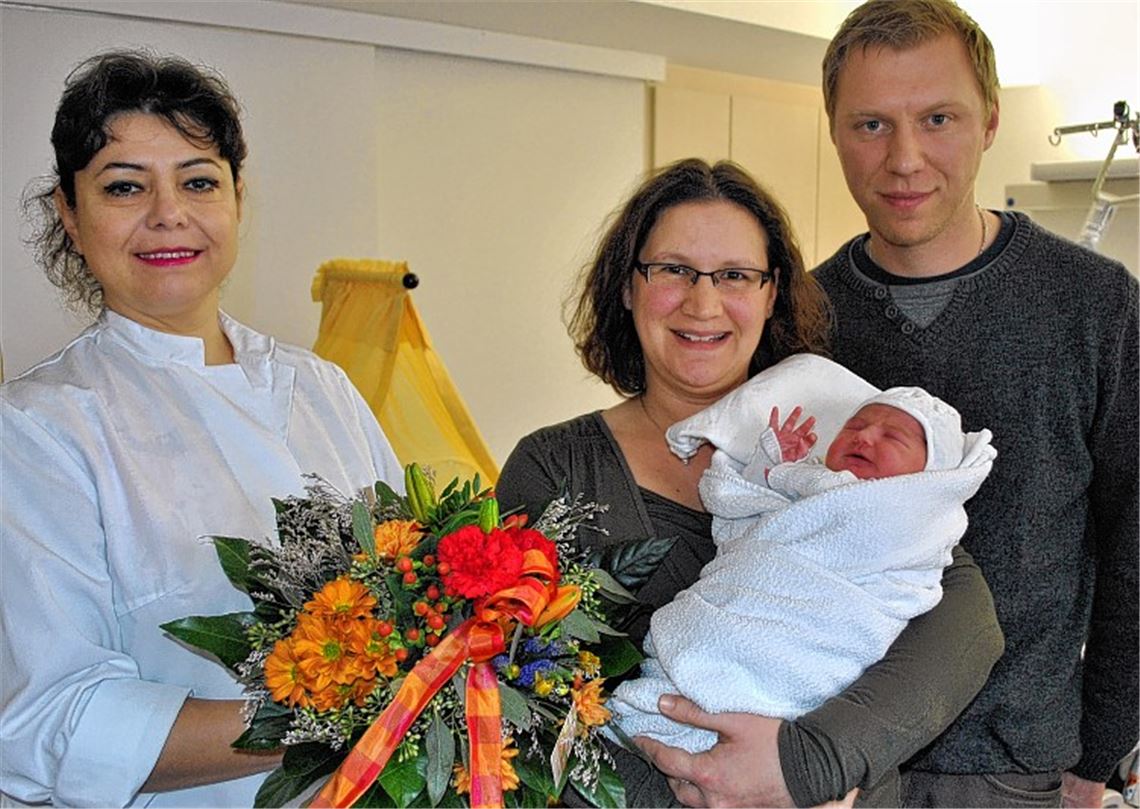 Blumen zum Start in ein neues Leben: Oberärztin Cezara Müller (li.) freut sich mit Sandra und Michael Knödl über die Geburt von Tochter Emily.Foto: Stahlfeld