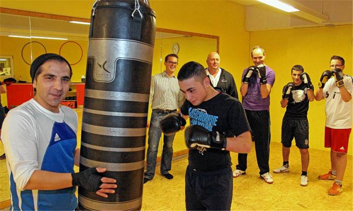 Boxtraining in Wiernsheim: Am Sandsack Trainer Dag Ismail mit Furkan Usta, im Hintergrund (v. li.) Kai-Joachim Ginser, stellvertretender Hauptamtsleiter, Michael Mlodzian vom Fitnesstreff Athletico, Jugendpfleger Benjamin Denk, Serhat Topalca und Kevin Braun. Foto: Goertz