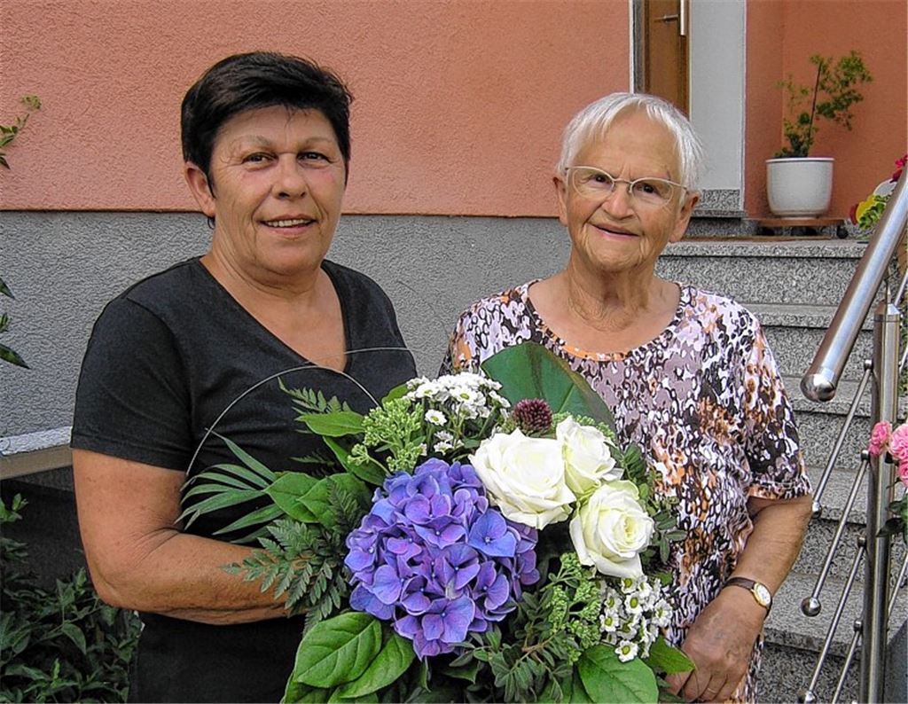 Brigitte Bürklin überreicht Martha Ebert (re.) ein blühendes Dankeschön.