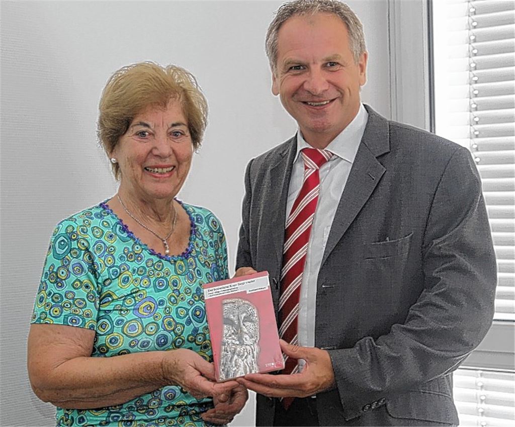 Brigitte Wetzel überreicht das Buch von Burkhard Metzger an Minister Reinhold Gall.