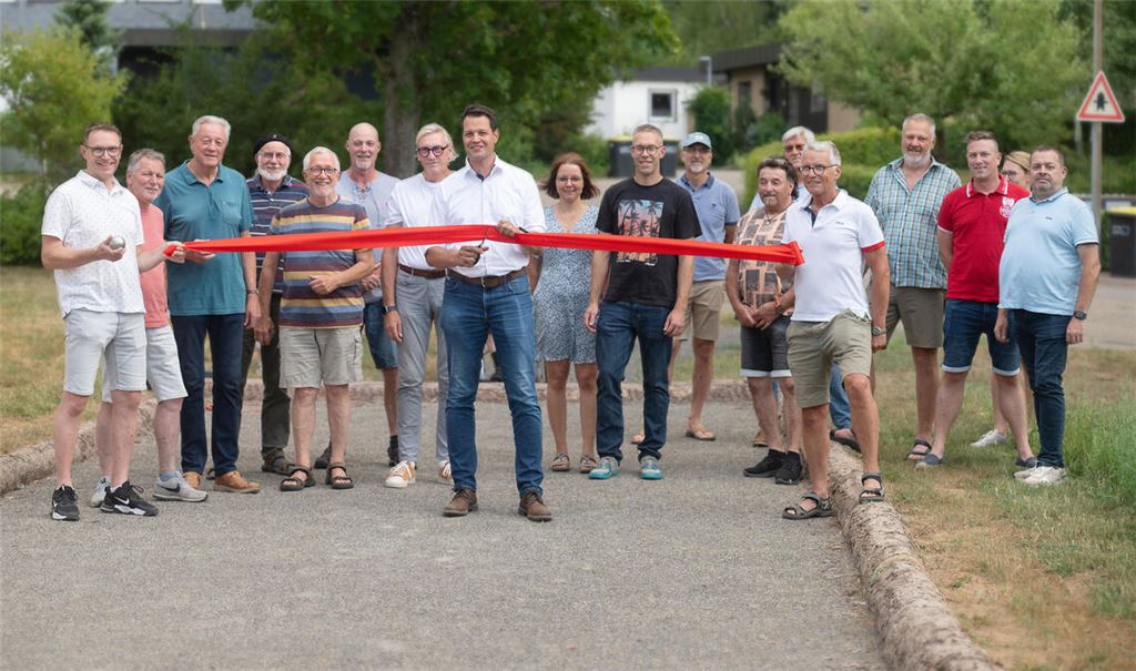 Bürgermeister Aaron Treut gibt im Beisein unter anderem von Gemeinderatsmitgliedern das Boule-Spielfeld auf der Grünfläche bei der Schefenacker-Turnhalle frei. Foto: Fotomoment