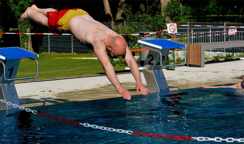Bürgermeister Alexander Kozel. der auch DLRG-Schwimmtrainer ist, wagt den Sprung ins (kühle) Nass und weiht das sanierte Paul-Kieselmann-Bad in Knittlingen ein. Fotos: Stahlfeld