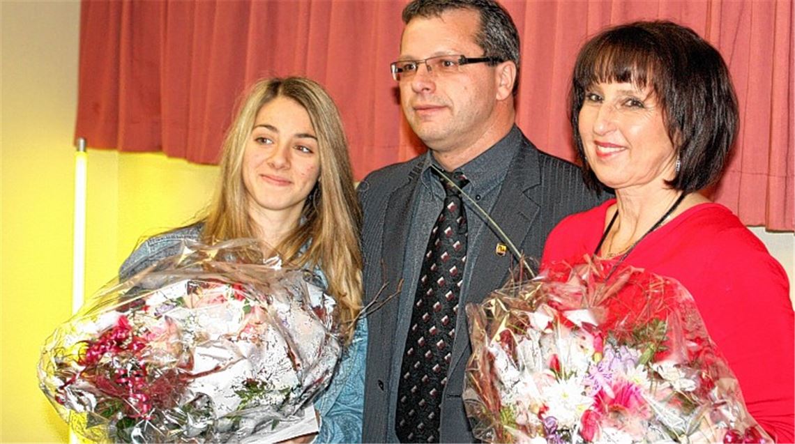 Bürgermeister Andreas Felchle bringt nicht nur Blumen für Anna Miggos (li.) und ihre Trainerin Désirée Gode-Elchlepp mit, sondern auch einen kleinen finanziellen Zuschuss. Foto: Westermann