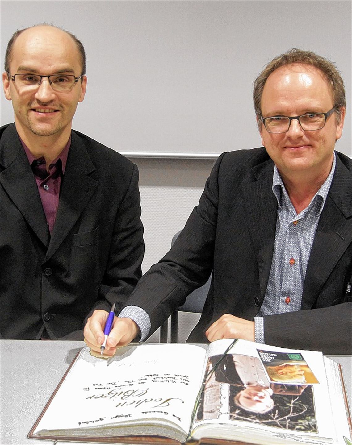 Bürgermeister Harald Eiberger freut sich, dass sich jetzt auch der renommierte Drehbuchautor Jochen Bitzer in das Goldene Buch seiner Heimatgemeinde Illingen einträgt. Foto: Goertz